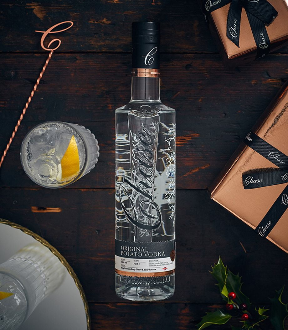 Chase vodka bottle shot on a table with glass and bar spoon