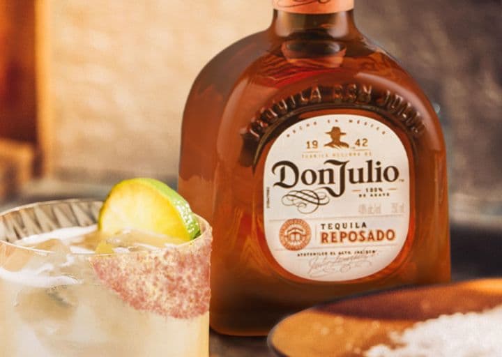 La imagen muestra una botella del tequila Don Julio Reposado junto a un vaso con el cóctel El Diablo.