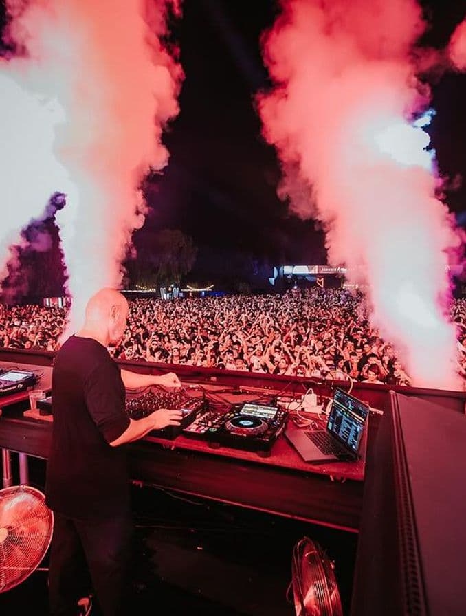 La imagen muestra la fiesta "Music On", con un DJ y un grupo grande de personas.